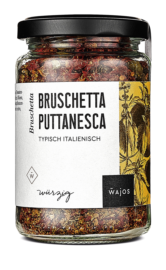 Das Bild zeigt ein Glas mit der Würzmischung "Bruschetta Puttanesca" von Wajos. Auf dem Etikett steht "typisch italienisch" und das Glas enthält 80 Gramm der Mischung.