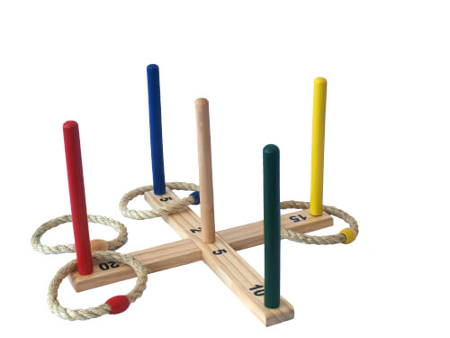 Das Bild zeigt ein Wurfspiel mit bunten Holzstäben und nummerierten Punkten auf einem Holzkreuz. Es liegen mehrere Wurfringe aus Seil auf den Stäben.