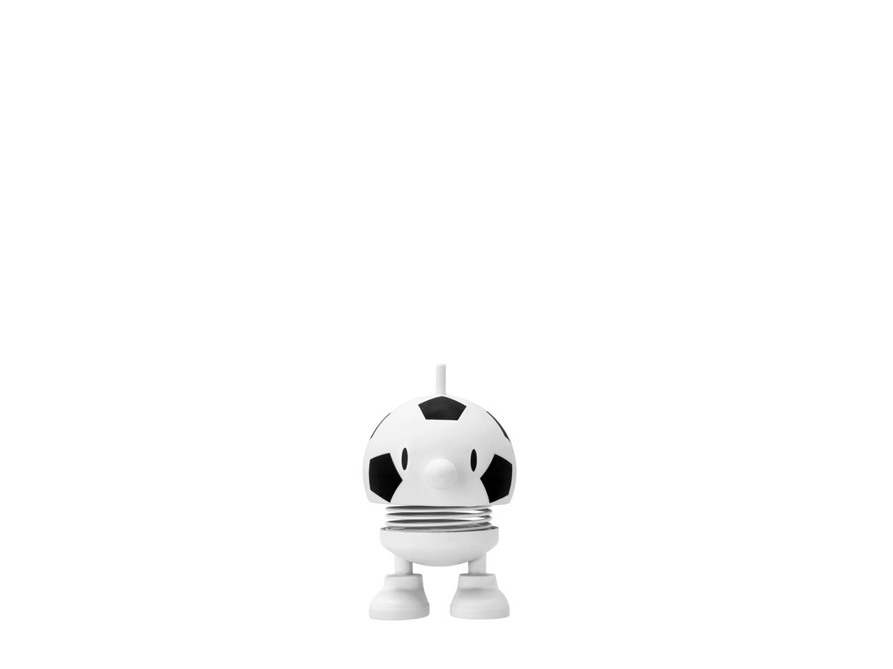 Das Bild zeigt eine kleine, weiße Figur im Design eines Fußballs. Die Figur steht auf zwei Beinen und hat eine Feder in der Mitte.