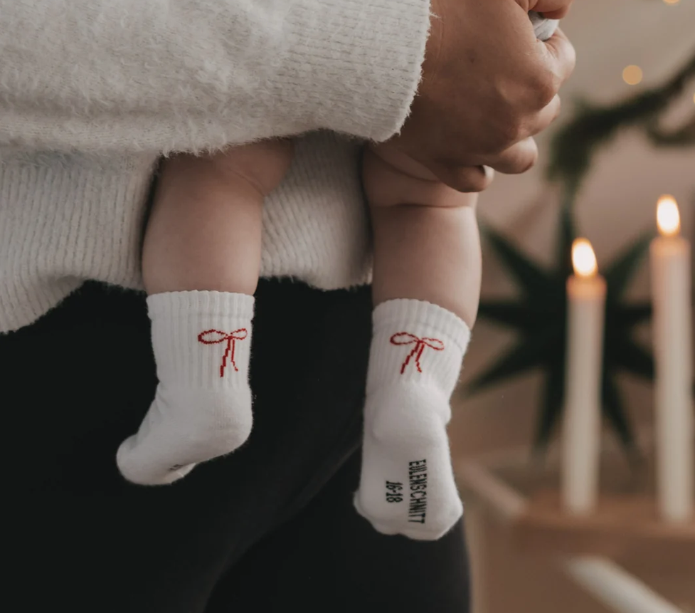 Babysocken Schleife in der Größe 16-18 werden dargestellt. Die Socken sind mit einer dekorativen Schleife verziert und für Babys geeignet.