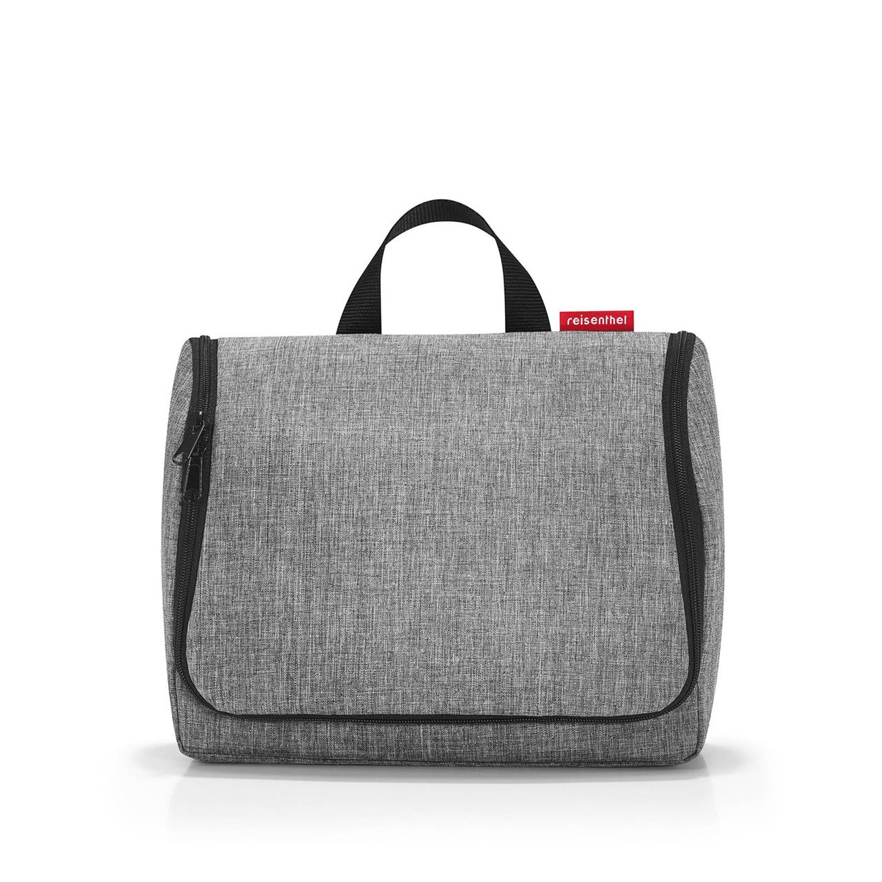 Die Abbildung zeigt eine graue Kosmetiktasche mit schwarzem Reißverschluss und Tragegriff. Auf der rechten Seite ist ein kleines rotes Label mit der Aufschrift "reisenthel" zu sehen.