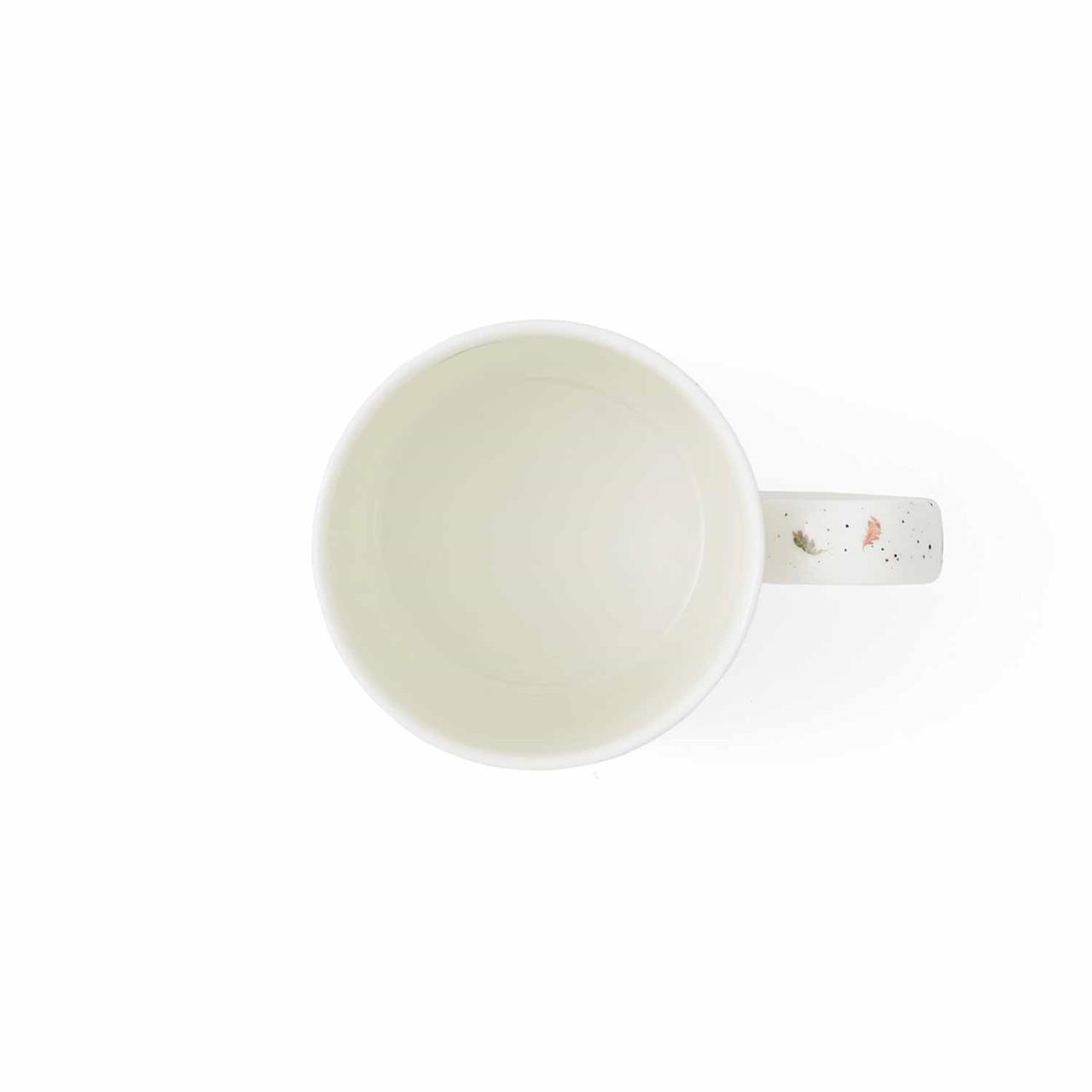 Die Abbildung zeigt eine weiße Tasse mit Henkel aus der Vogelperspektive. Auf dem Henkel sind kleine, bunte Motive zu sehen.