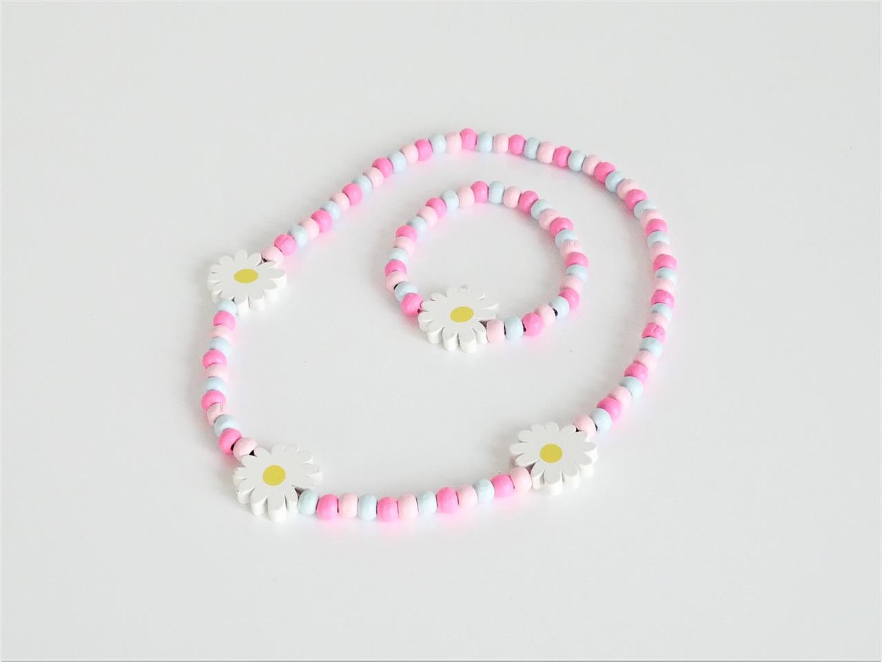 Das Bild zeigt ein buntes Set aus einer Kette und einem Armband mit Holzperlen in Rosa, Weiß und Hellblau. Beide Schmuckstücke sind mit weißen Margeriten-Anhängern verziert.