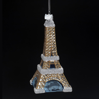 Das Bild zeigt einen Weihnachtsbaumschmuck in Form des Eiffelturms. Die Dekoration ist detailliert gestaltet und glänzt in Gold und Silber.