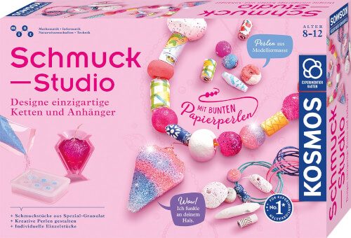 Auf dem Bild ist eine Schmuckstudio-Bastelbox mit bunten Perlen und Schmuckstücken zu sehen. Die Verpackung ist überwiegend rosa und richtet sich an Kinder im Alter von 8 bis 12 Jahren.