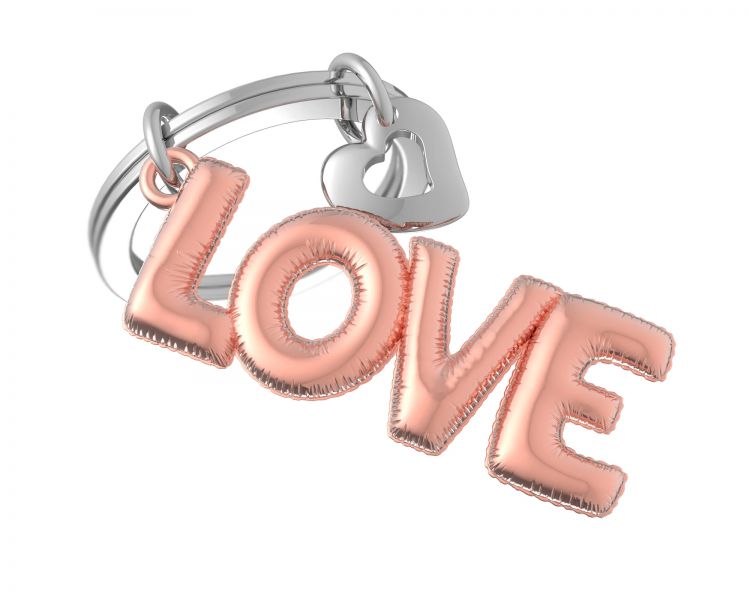 Der Schlüsselanhänger zeigt das Wort "LOVE" in kupferfarbener Optik. Zusätzlich ist ein kleiner Herzanhänger in Chrom angebracht.