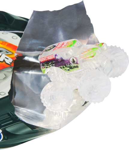 Auf dem Bild ist ein kleines, durchsichtiges Spielzeugauto zu sehen. Es befindet sich auf einer silbernen Folie und teilweise auf einer Verpackung.