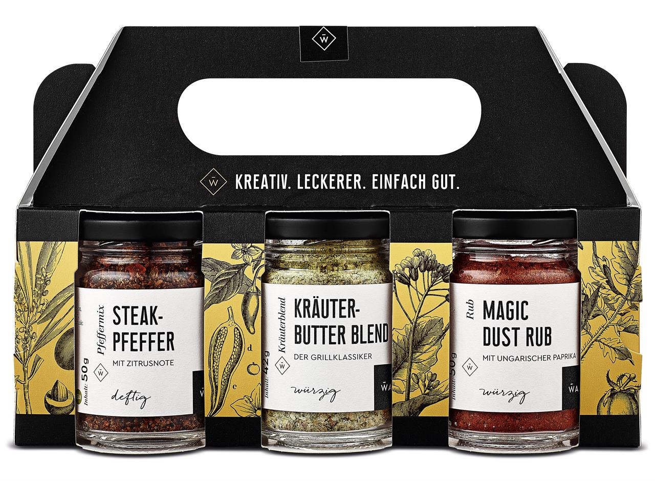 Das Bild zeigt ein Kräuter-Set mit drei Gewürzen: Steakpfeffer, Kräuterbutter-Blend und Magic Dust Rub. Die Verpackung ist schwarz-gelb und trägt den Slogan "Kreativ. Leckerer. Einfach gut."