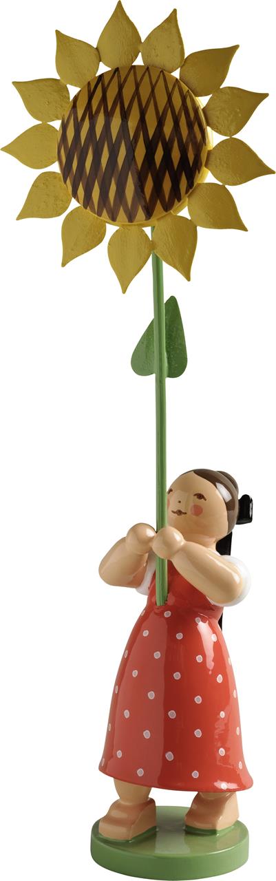 Das Bild zeigt eine kleine Figur eines Mädchens mit einem roten Kleid mit weißen Punkten. Sie hält eine große Sonnenblume in den Händen.