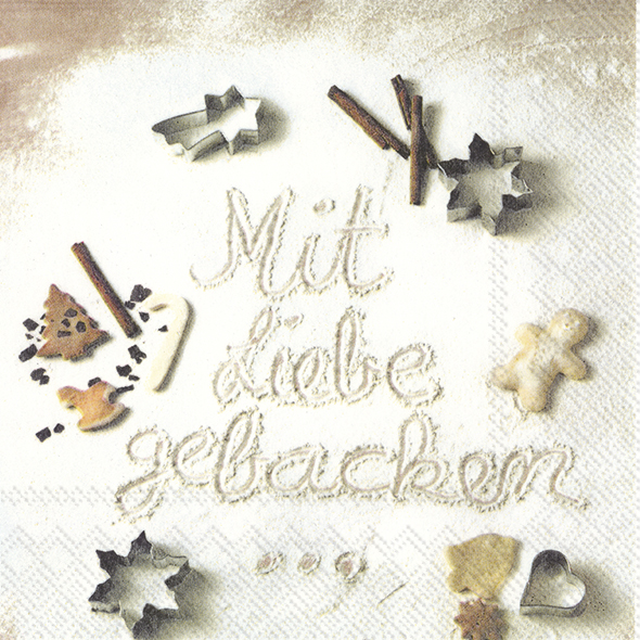 Auf der Serviette steht „Mit Liebe gebacken“ in Mehl geschrieben. Drumherum liegen Kekse, Ausstechformen und Zimtstangen.