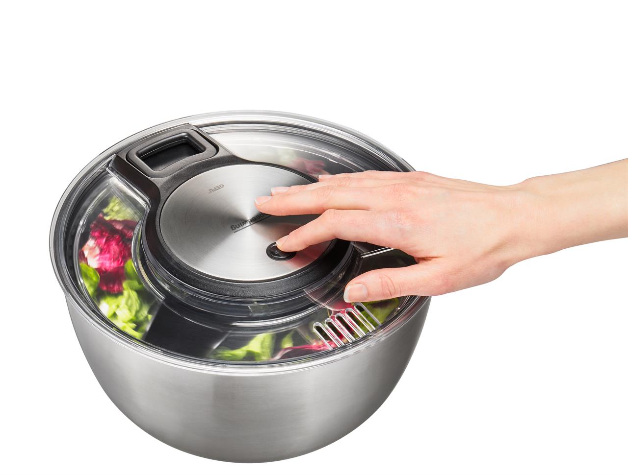 Auf dem Bild ist eine Hand zu sehen, die eine Salatschleuder SPEEDWING® aus Edelstahl bedient. Im Inneren der Schüssel befinden sich bunte Salatblätter.