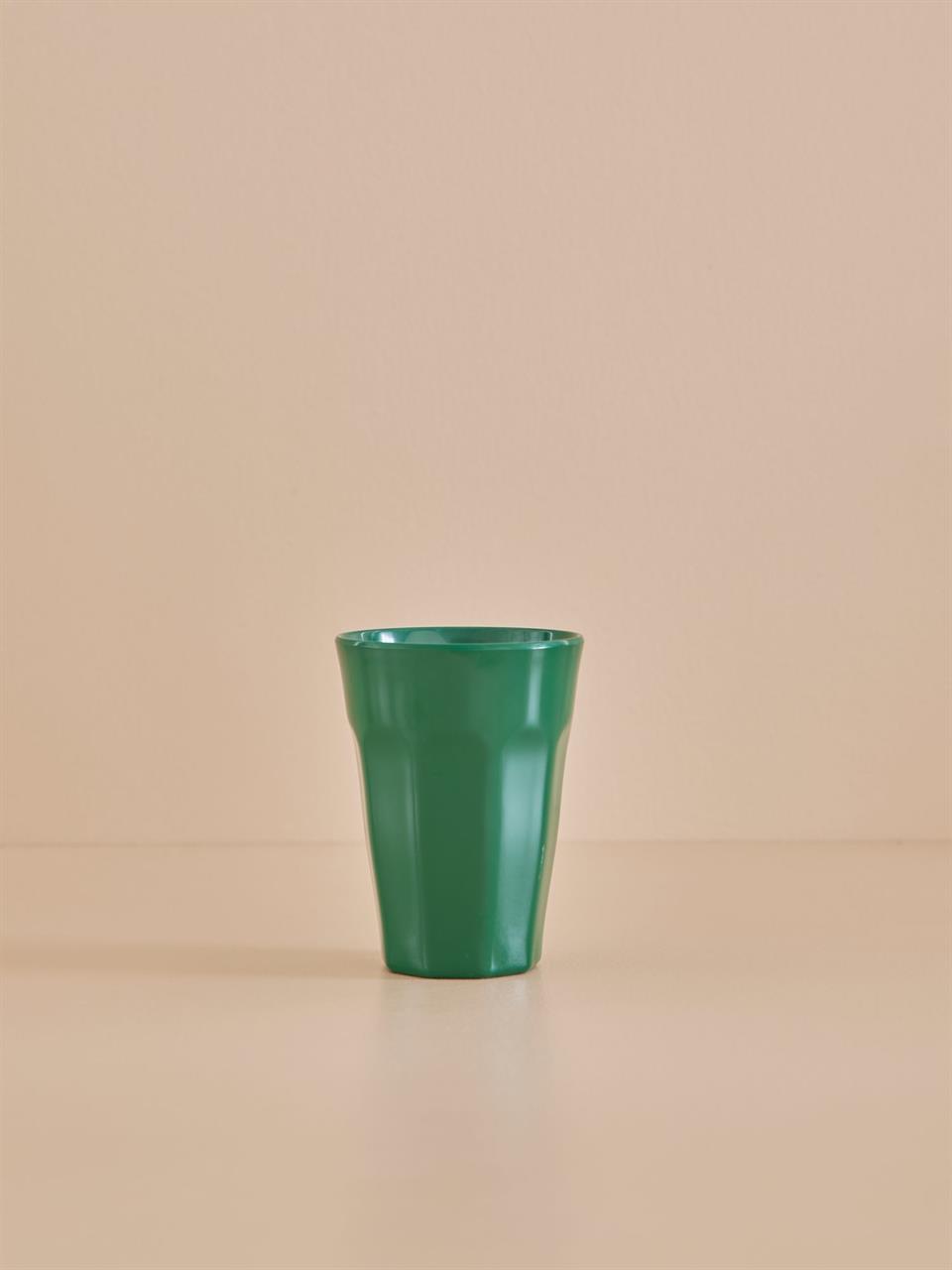 Auf dem Bild ist ein hoher Becher aus Melamin in Dunkelgrün zu sehen. Der Becher steht auf einer ebenen, beigefarbenen Oberfläche vor einem beigefarbenen Hintergrund.