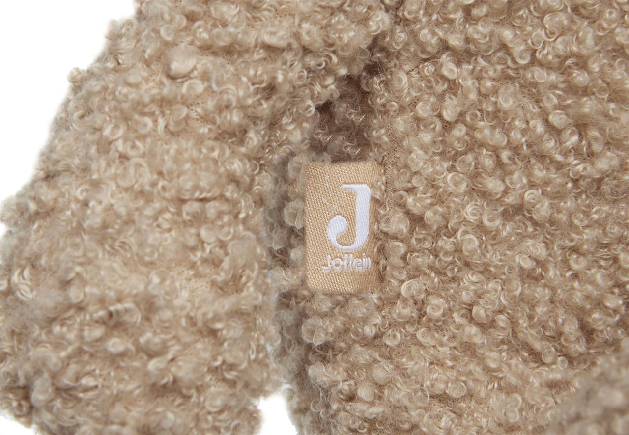 Das Bild zeigt ein Nahaufnahme des kuscheligen Stoffes eines Teddybären namens "Biscuit". Auf dem Stoff ist ein kleines Etikett mit dem Buchstaben "J" und dem Wort "Jollein" zu sehen.