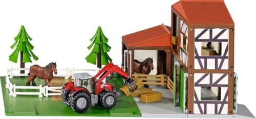 Auf dem Bild ist ein Spielzeugbauernhof mit einem Traktor, zwei Pferden und einem Stall zu sehen. Im Hintergrund stehen zwei grüne Bäume und ein weißer Zaun umgibt die Pferdekoppel.