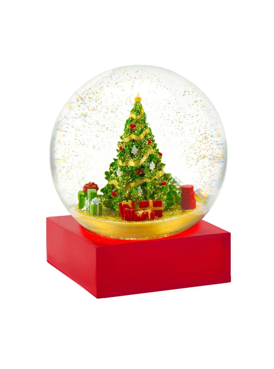 In der Schneekugel ist ein festlich geschmückter Weihnachtsbaum mit Geschenken zu sehen. Sie steht auf einem roten Sockel und ist 12x10x10 cm groß.
