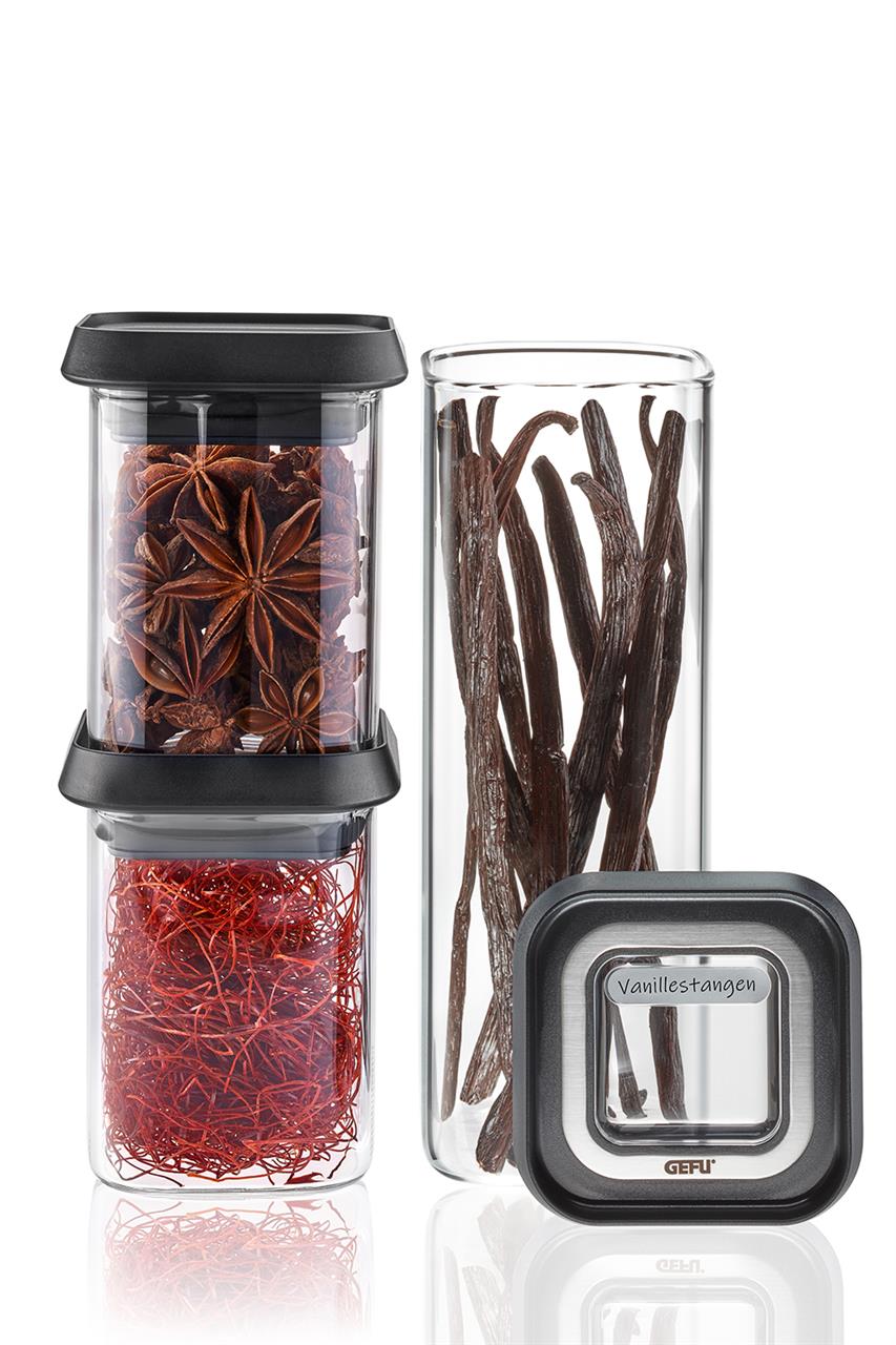 Das Bild zeigt ein dreiteiliges Vorratsdosen-Set namens PANTRY, Mini. Die transparenten Dosen mit schwarzen Deckeln sind mit verschiedenen Gewürzen befüllt.