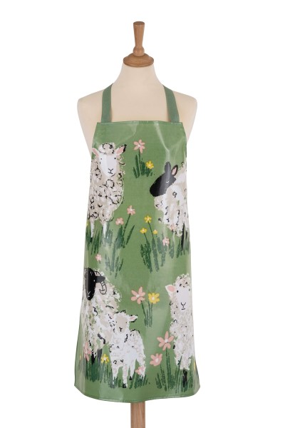 Die Abbildung zeigt eine PVC-Schürze mit dem Motiv "Woolly Sheep". Auf der grünen Schürze sind mehrere Schafe und bunte Blumen abgebildet.