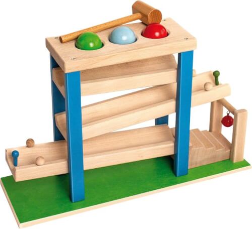Das Bild zeigt ein Holzspielzeug mit bunten Kugeln, einer Rampe und einem Hammer. Die Kugeln können mit dem Hammer eingeklopft werden und rollen dann die Rampe hinunter.