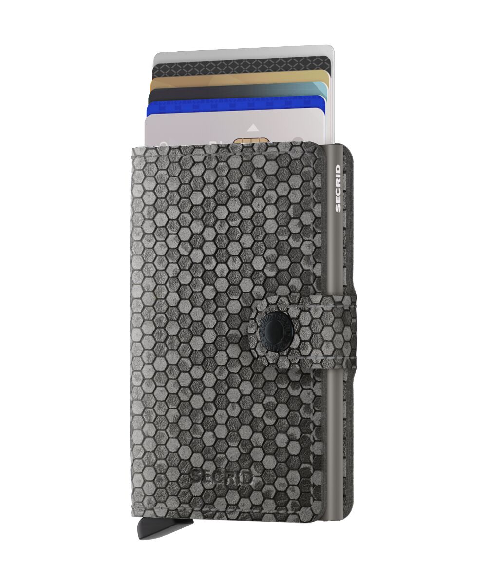 Das Bild zeigt ein Miniwallet Hexagon Grey mit einem grauen sechseckigen Muster. Aus dem Wallet schauen mehrere Karten oben heraus.