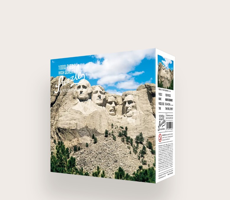 Das Bild zeigt das Produkt 'Puzzle Mount Rushmore 1000 Teile'. Es handelt sich um ein Puzzle mit 1000 Teilen und einem Motiv von Mount Rushmore.