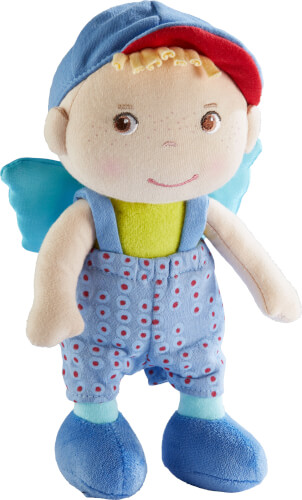 Das Bild zeigt eine weiche Stoffpuppe mit blauer Hose und Mütze. Die Puppe hat blonde Haare und trägt Flügel auf dem Rücken.