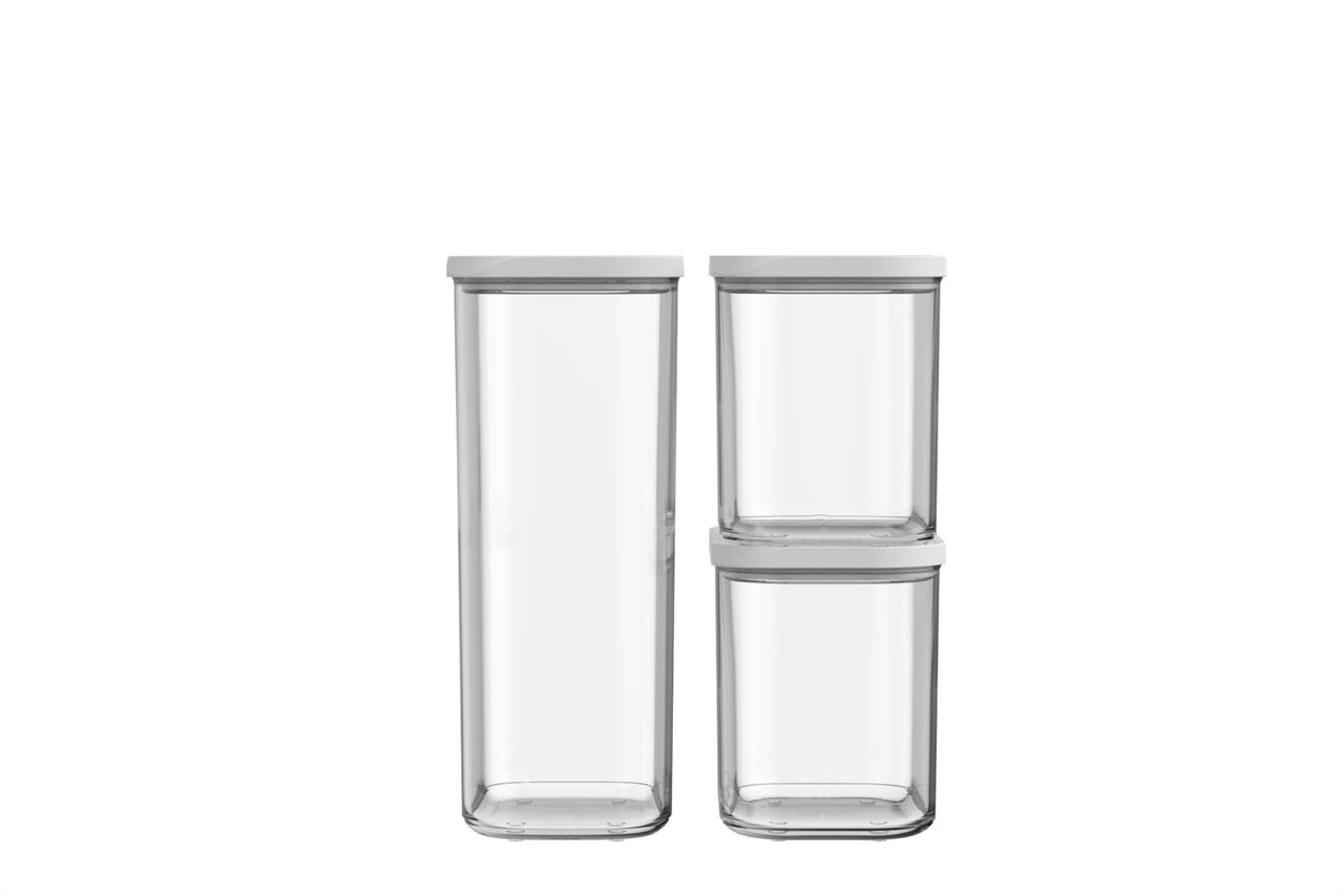 Das Bild zeigt ein Vorratsdosen-Starterset bestehend aus drei transparenten Behältern mit weißen Deckeln. Zwei der Dosen sind quadratisch und übereinandergestapelt, die dritte Dose ist größer und steht daneben.